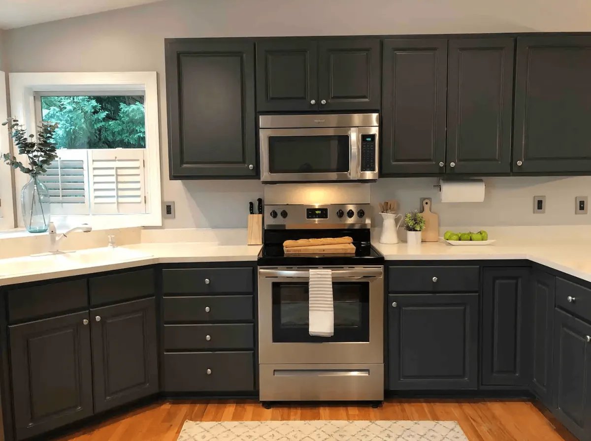 A warm, welcoming kitchen scene showcasing ample cabinetry, stainless steel appliances, and a central island, with windows letting in greenery from outside. Decorative items on the countertop and thoughtful lighting create a cozy, homelike feel, reinforcing the idea of a well-equipped chef’s kitchen ready for memorable holiday or family meals.